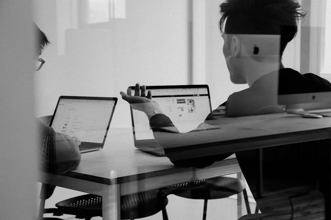 Team discussing ideas around a table with laptops