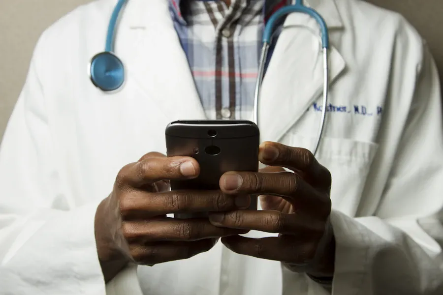 Healthcare professional holding a smartphone with a stethoscope around their neck