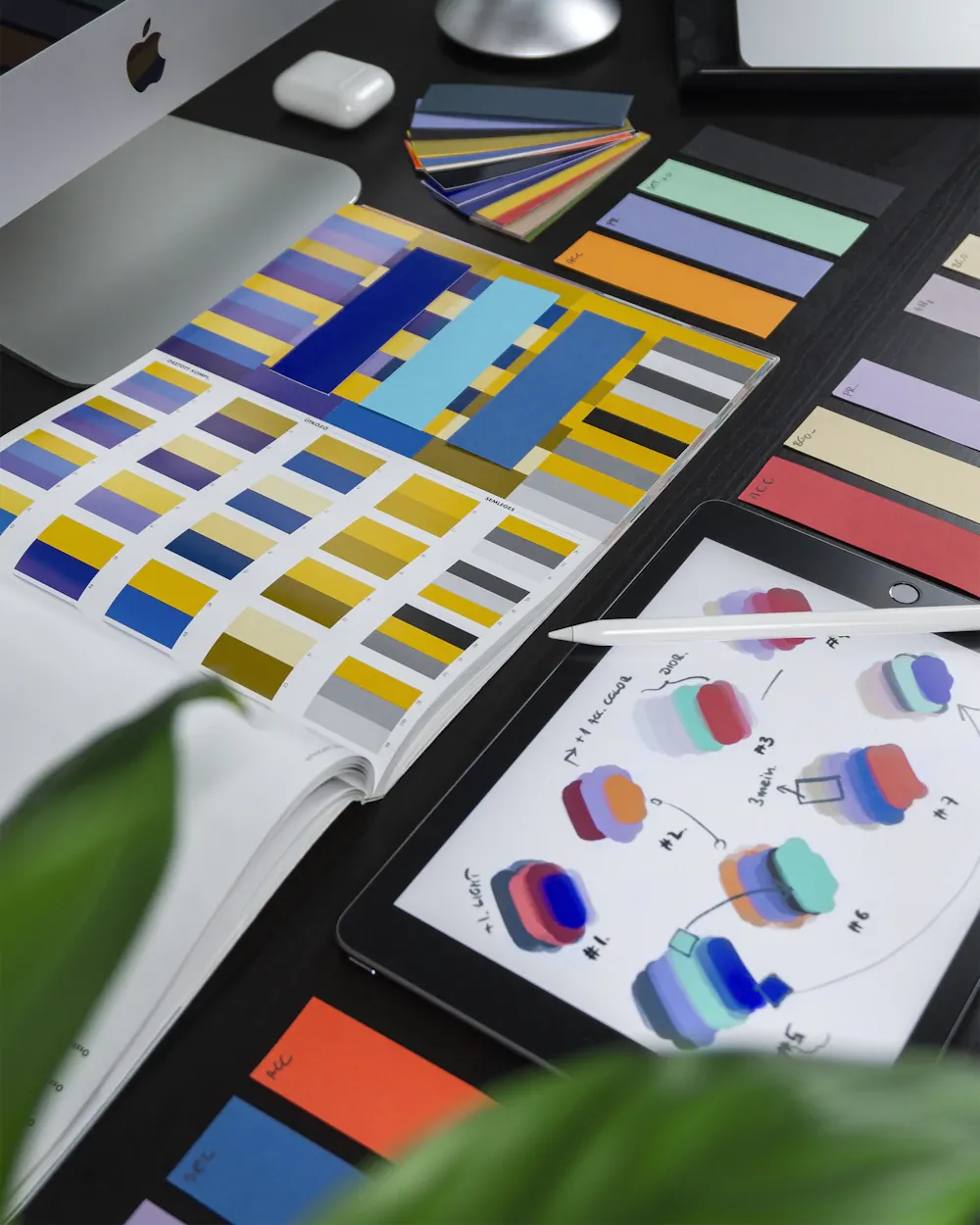 Printed colour palettes and visual design layouts on a desk